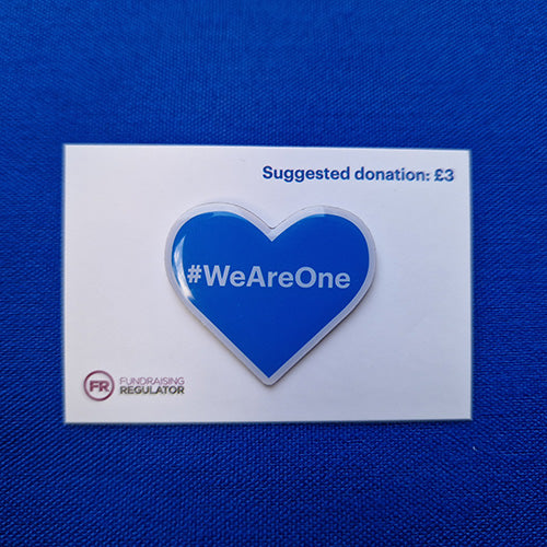 Heart shaped blue pin badge we #WeAreOne in white lettering